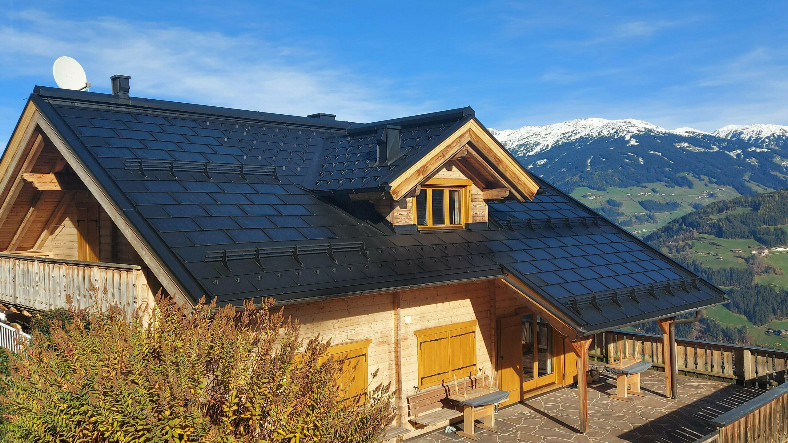 Sanacija enodružinske hiše v kraju Hippach (Tirolska) z malo solarno strešno ploščo PREFA v barvi P.10 črna v kombinaciji s strešno ploščo PREFA R.16.