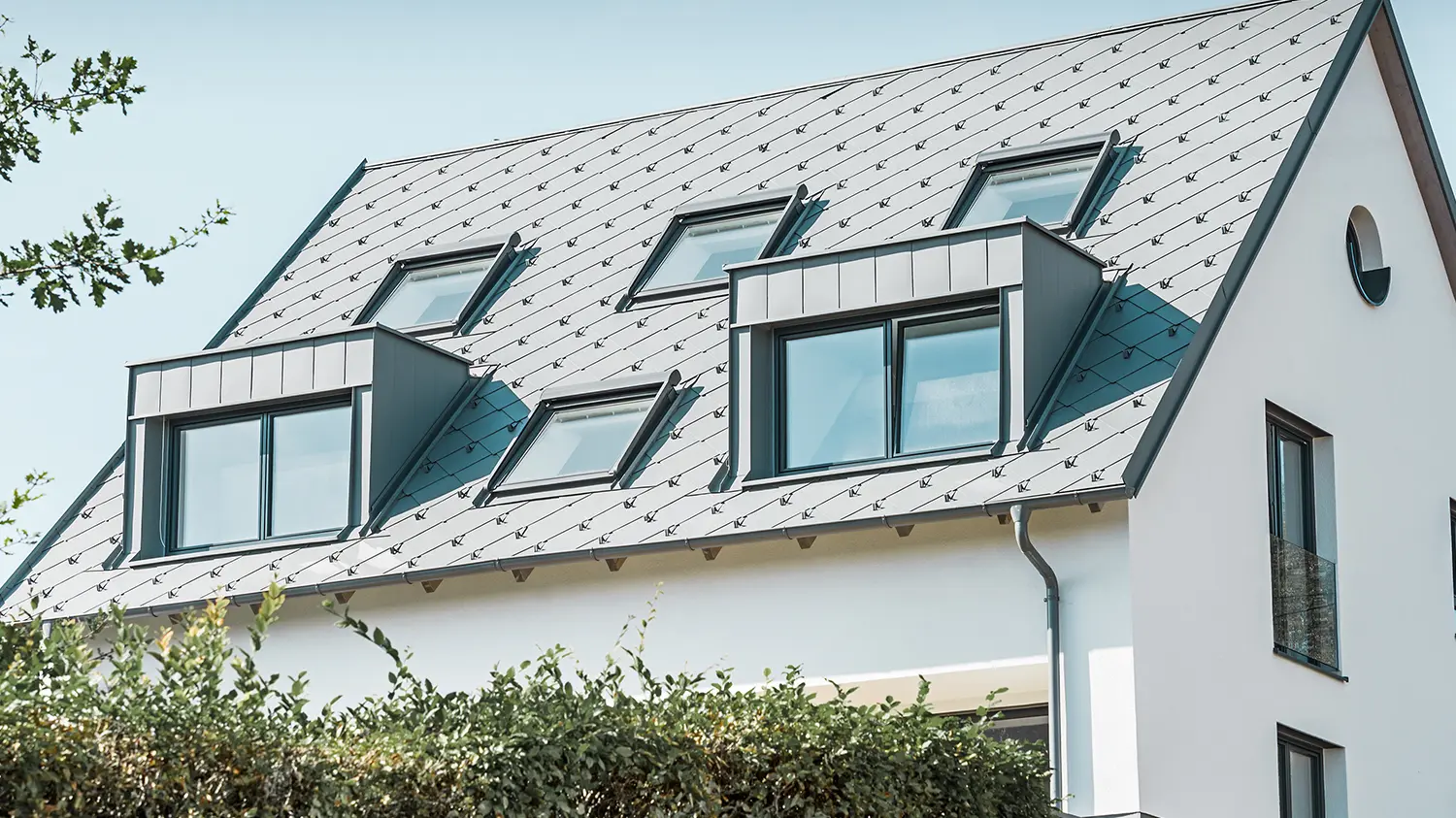 Prenova dvokapne strehe z dvema frčadama in štirimi strešnimi okni; streha je bila prekrita s strešniki PREFA 44 × 44 v svetlo sivi barvi. Žleb je viseči žleb PREFA, prav tako v svetlo sivi barvi. 