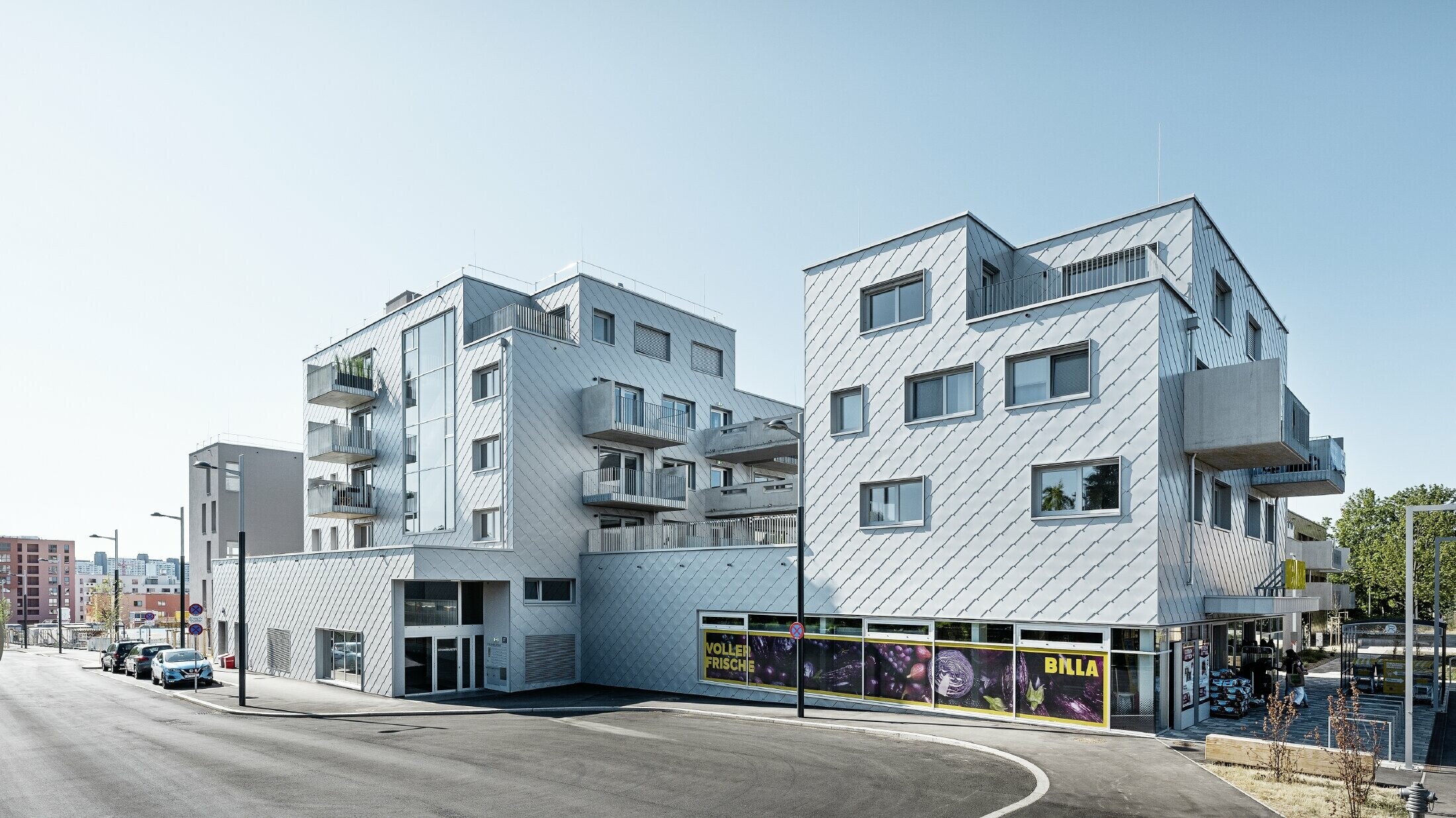 Stanovanjska naselja z ravnimi strehami in fasadnimi rombi 44 x 44 PREFA na fasadi v kovinsko srebrni barvi