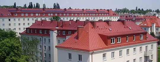 Slika hiš Hugo Breitner Hof na Dunaju. Strehe so bile prekrite s strešno skodlo PREFA v opečno rdeči barvi.
