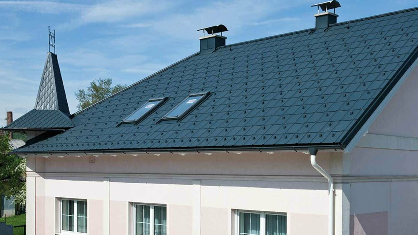 Hiša v Avstriji po obnovi strehe s strešnimi ploščami PREFA (pred tem – streha s strešniki iz vlaknocementa Eternit s stolpičem in roza fasado)