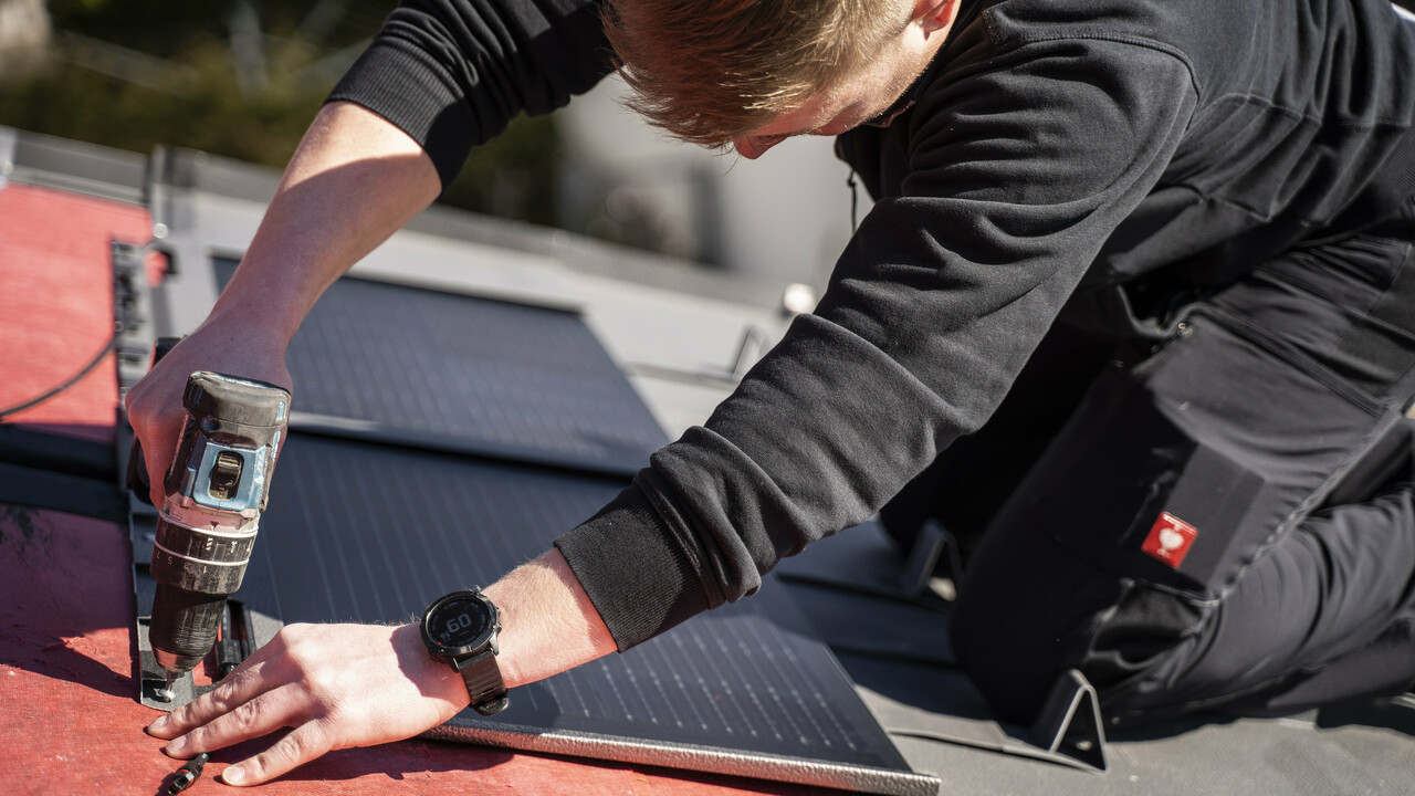 Sodelavec podjetja PREFA pri polaganju solarne strešne plošče.