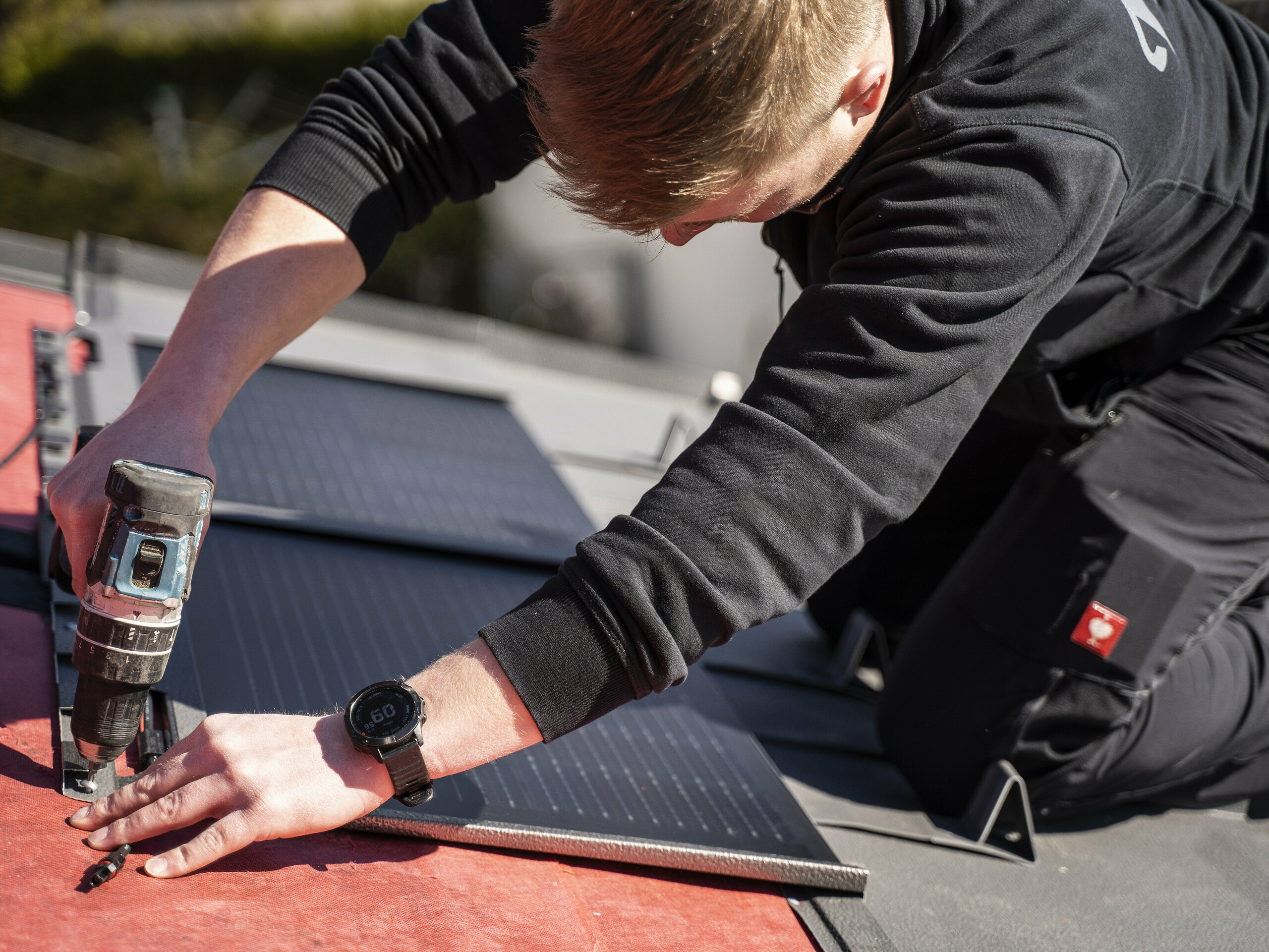 Sodelavec podjetja PREFA pri polaganju solarne strešne plošče.