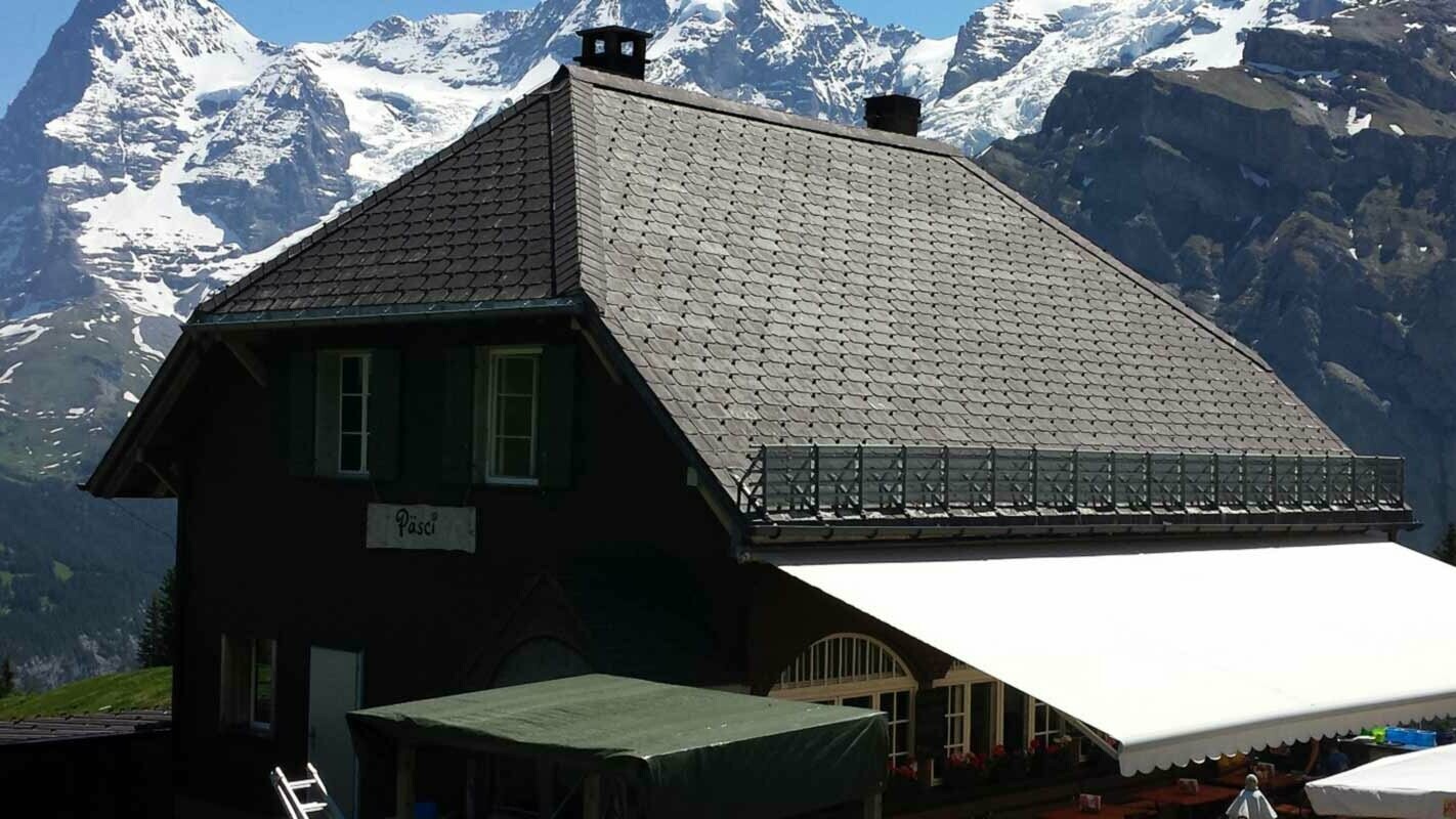 Gorska koča s čopasto streho pred obnovo strehe s strešnimi skodlami PREFA in snegolovi