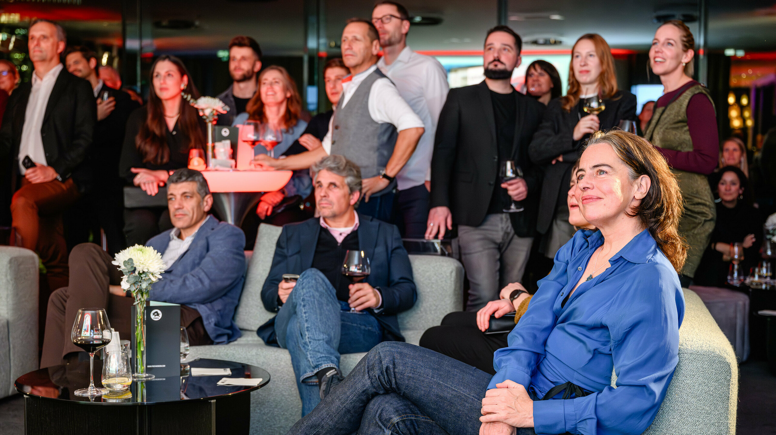 Osredotočeni pogledi in navdušeni obrazi na predstavitvi PREFARENZEN 2026 v k47.wien: gostje pozorno spremljajo multimedijsko predstavitev najnovejših projektov PREFA. Učinkovita svetlobna kulisa in elegantno vzdušje odražata kakovost predstavljenih aluminijastih rešitev. Scena kaže: PREFA ustvarja prostor za inovacije, izmenjavo in ustvarjalne vizije. Večer, ki v središče postavlja moč brezčasne arhitekture in raznolikost sodobnih možnosti oblikovanja z aluminijem.