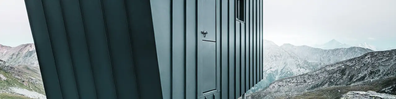 BCW Collective entschieden sich für Minimalismus, ortsbezogenen Nachhaltigkeit und eine auf das Notwendigste reduzierte Funktionalität. Die anthrazitfarbene PREFALZ-Hütte wirkt wie eine Art Wegweiser.