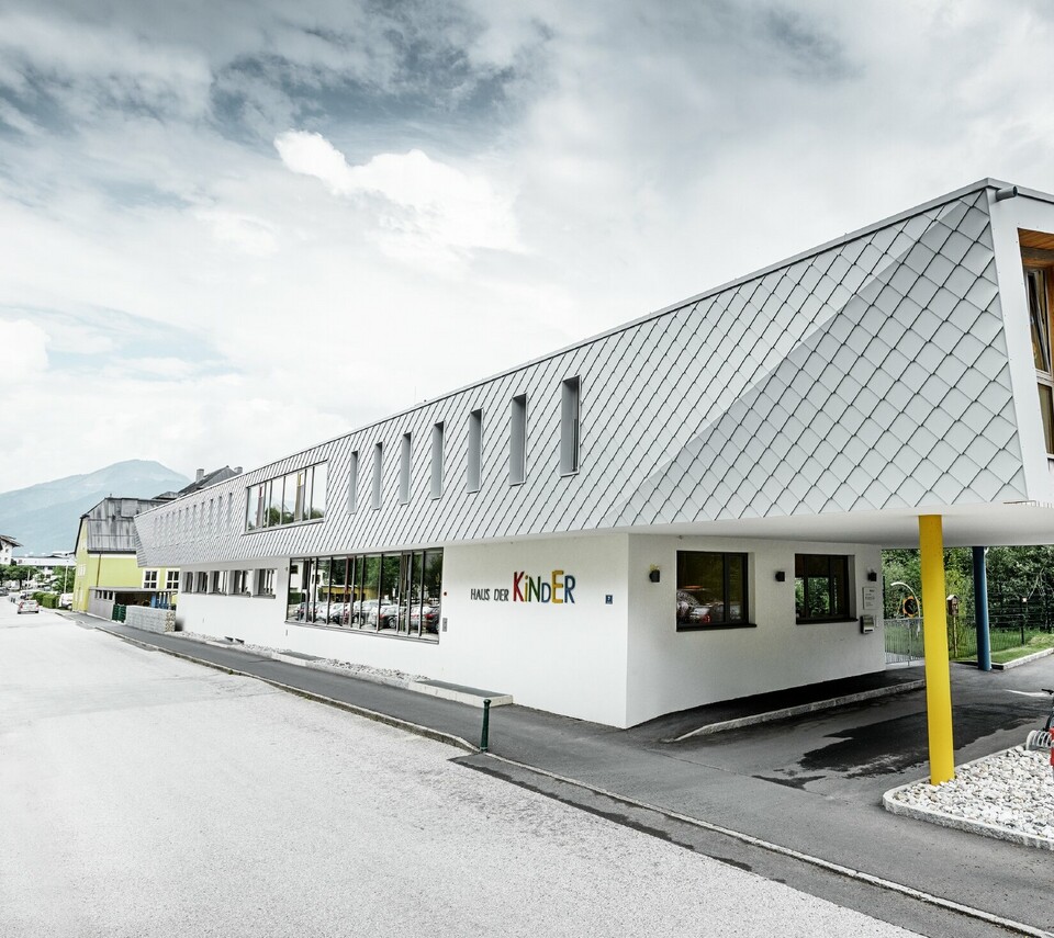 Novozgrajen vrtec v Kaprunu s sodobno aluminijasto fasado s stenskimi rombi PREFA v PREFA-beli barvi