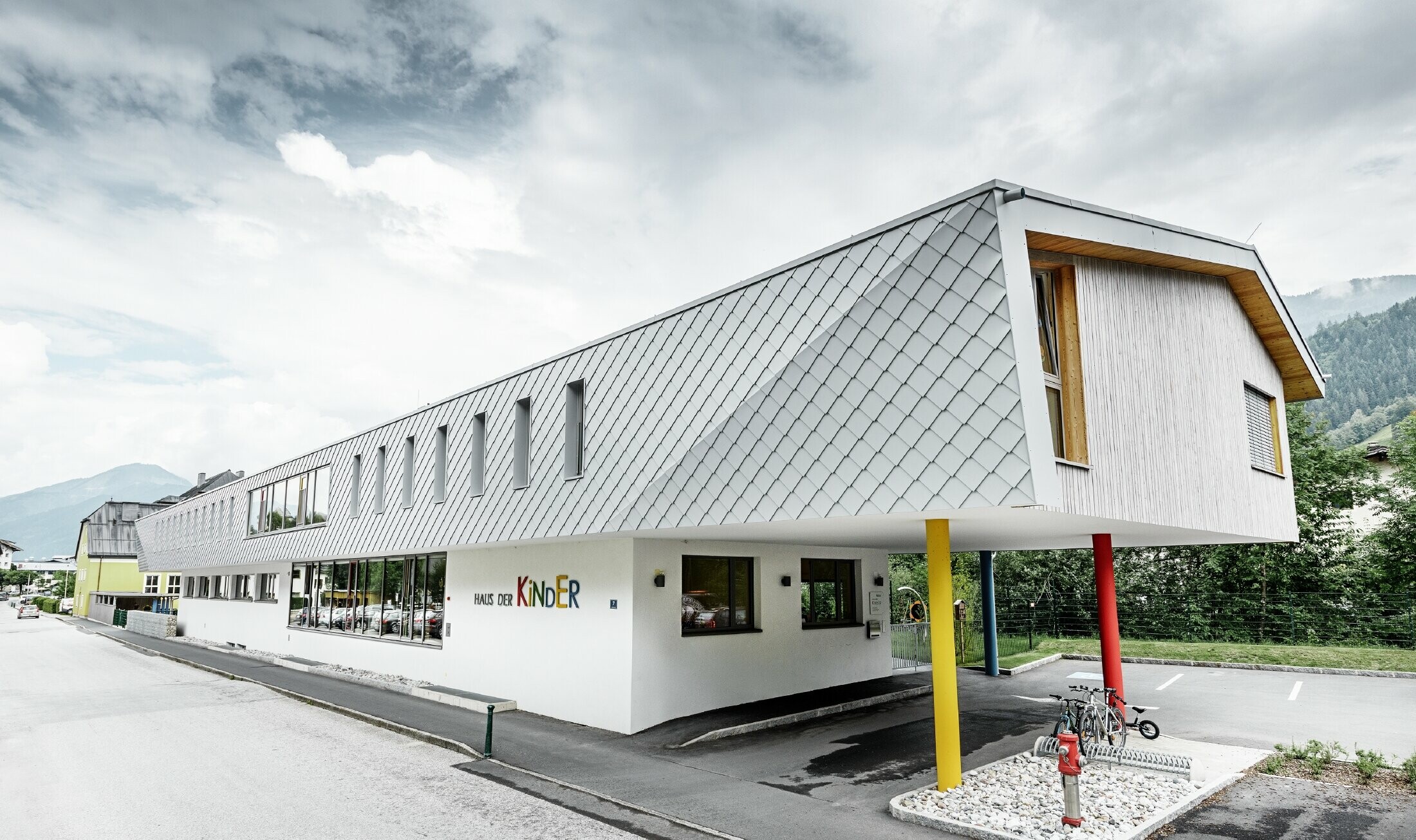 Novozgrajen vrtec v Kaprunu s sodobno aluminijasto fasado s stenskimi rombi PREFA v PREFA-beli barvi