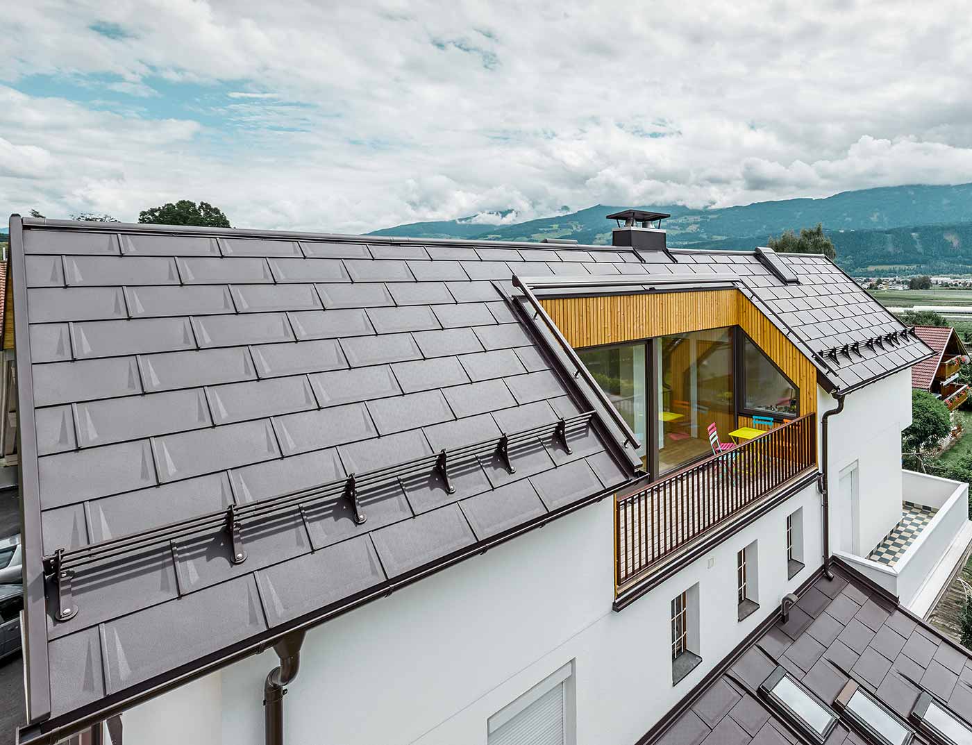 PREFA Dachplatte R.16 Nussbraun Referenz Mehrparteienhaus mit großzügiger Logia - Das Dach ist mit der PREFA Dachplatte R.16 in Nussbraun eingedeckt.