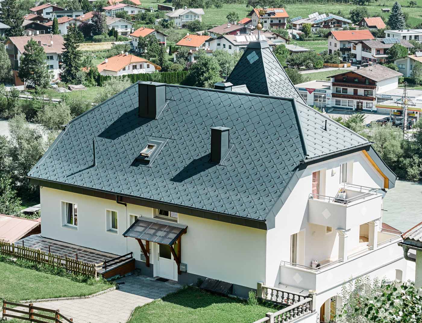 PREFA Dachraute 44 × 44 Anthrazit Referenz Küppelwalmdach mit einem Turm, eingedeckt mit der Aluminium Dachraute 44 × 44 in Anthrazit.