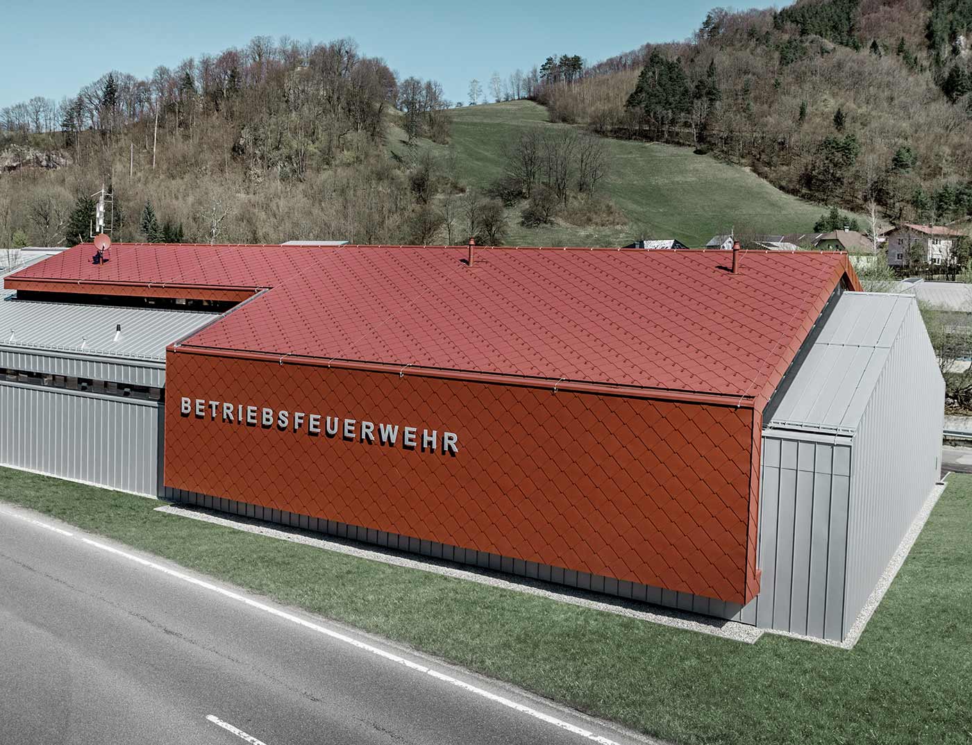 PREFA Dachraute 44 × 44 Oxydrot Referenz Das neue Feuerwehrhaus der Betriebsfeuerwehr der Firmen PREFA und Neuman Aluminium wurde mit der neuen Dach- und Wandraute 44 × 44 in P.10 Oxydrot sowie Prefalz in Silbermetallic verkleidet.